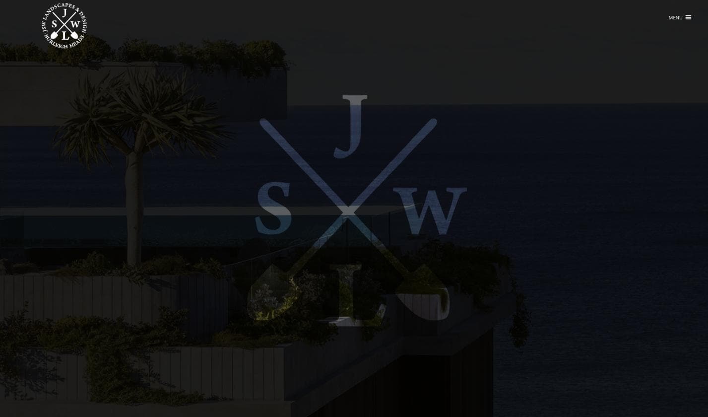 JSW Landscapes & Design homepage — a night shot of a coastal infinity-edge pool and terraced garden with the ocean beyond, overlaid with the JSW crossed-shovel emblem